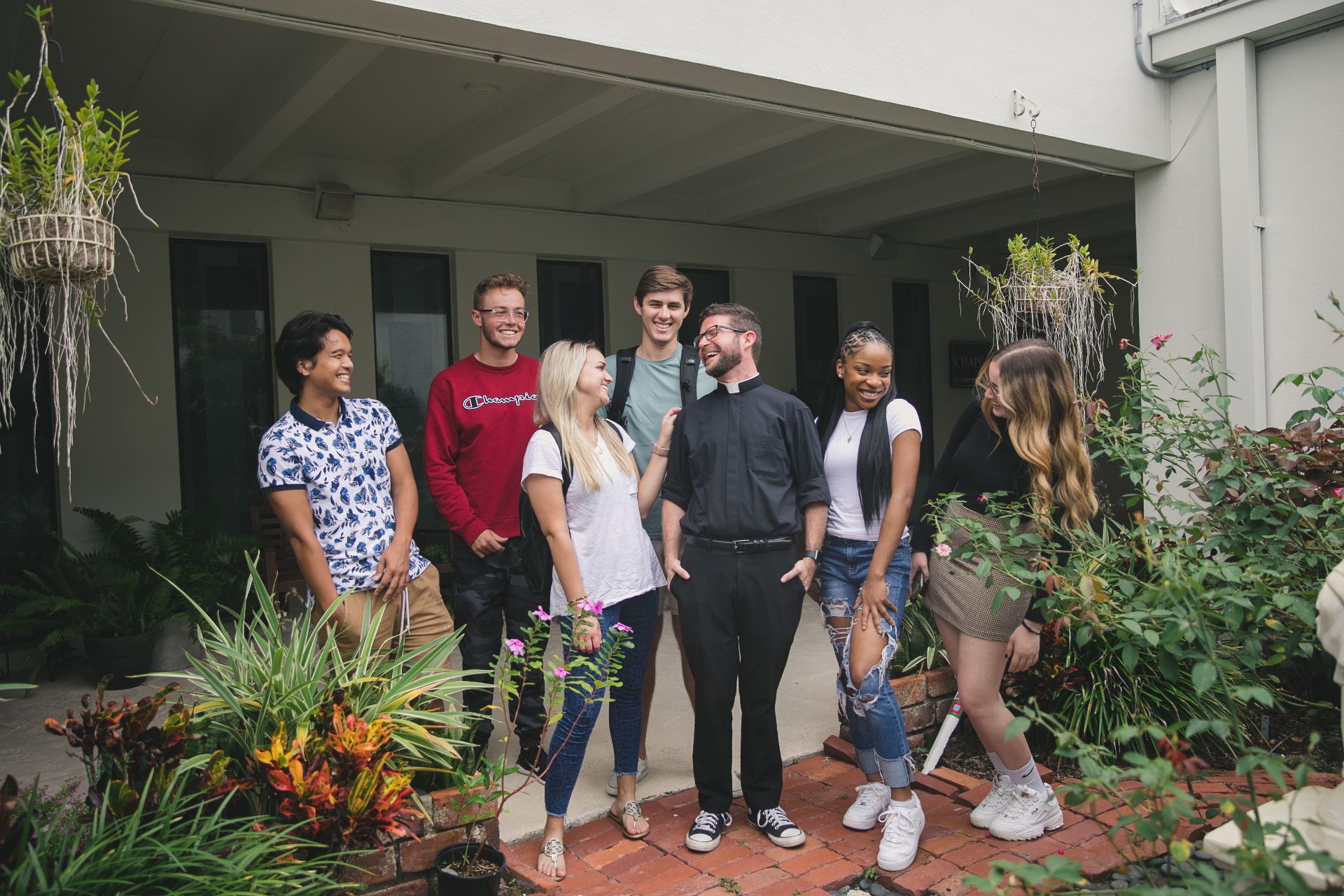 Students and chaplain laughing together in courtyard